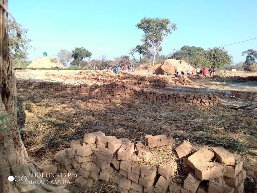 Stacks of community-moulded bricks ready for construction in Simooya