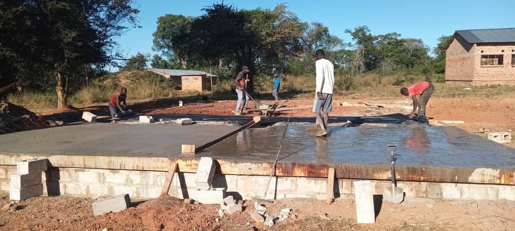 Workers levelling the freshly poured concrete floor slab