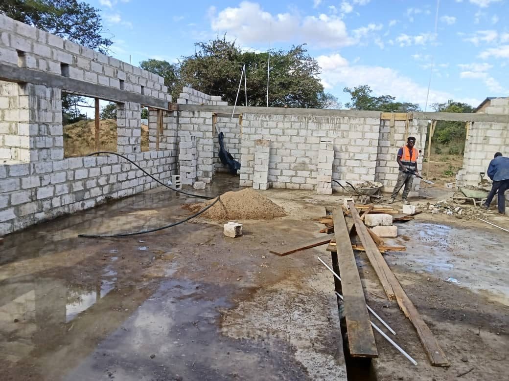 Workers busy inside the building as walls near completion