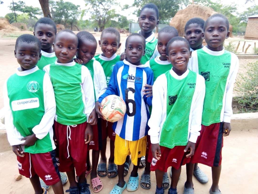 Young players wearing donated football kits